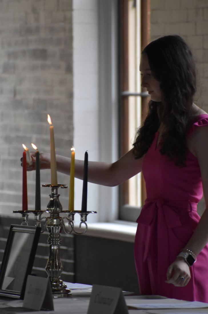 Lily Arnberg (12) lights the fourth candle at the HHS National Honor Society Induction Ceremony. 